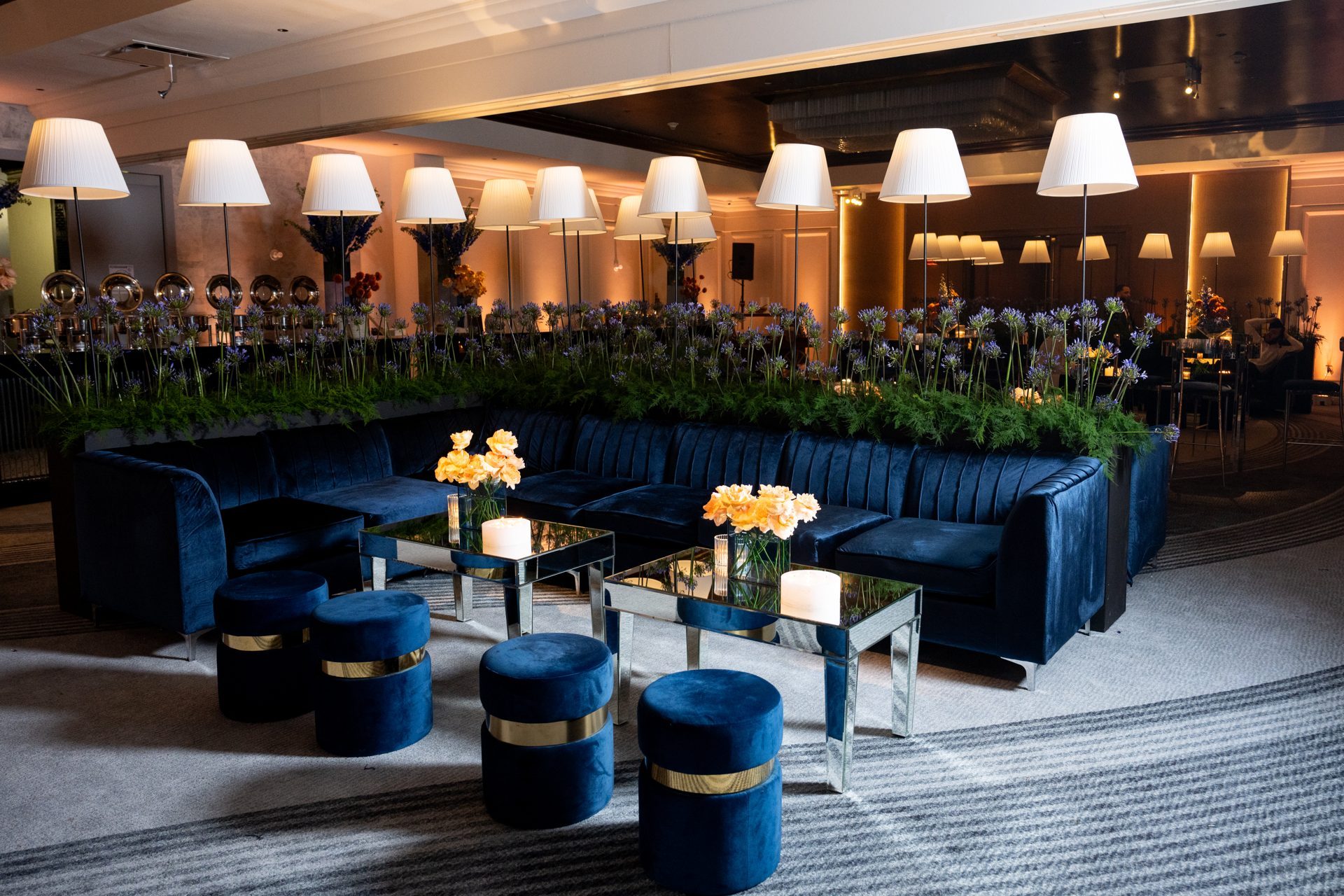 Navy velvet lounge seating under lamplight at an event