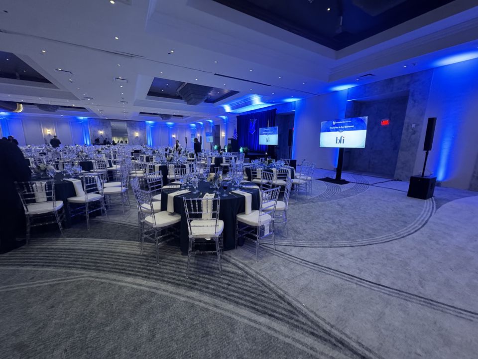 The Horizon Ballroom set for a Meadowlands Chamber dinner, the stage under blue light