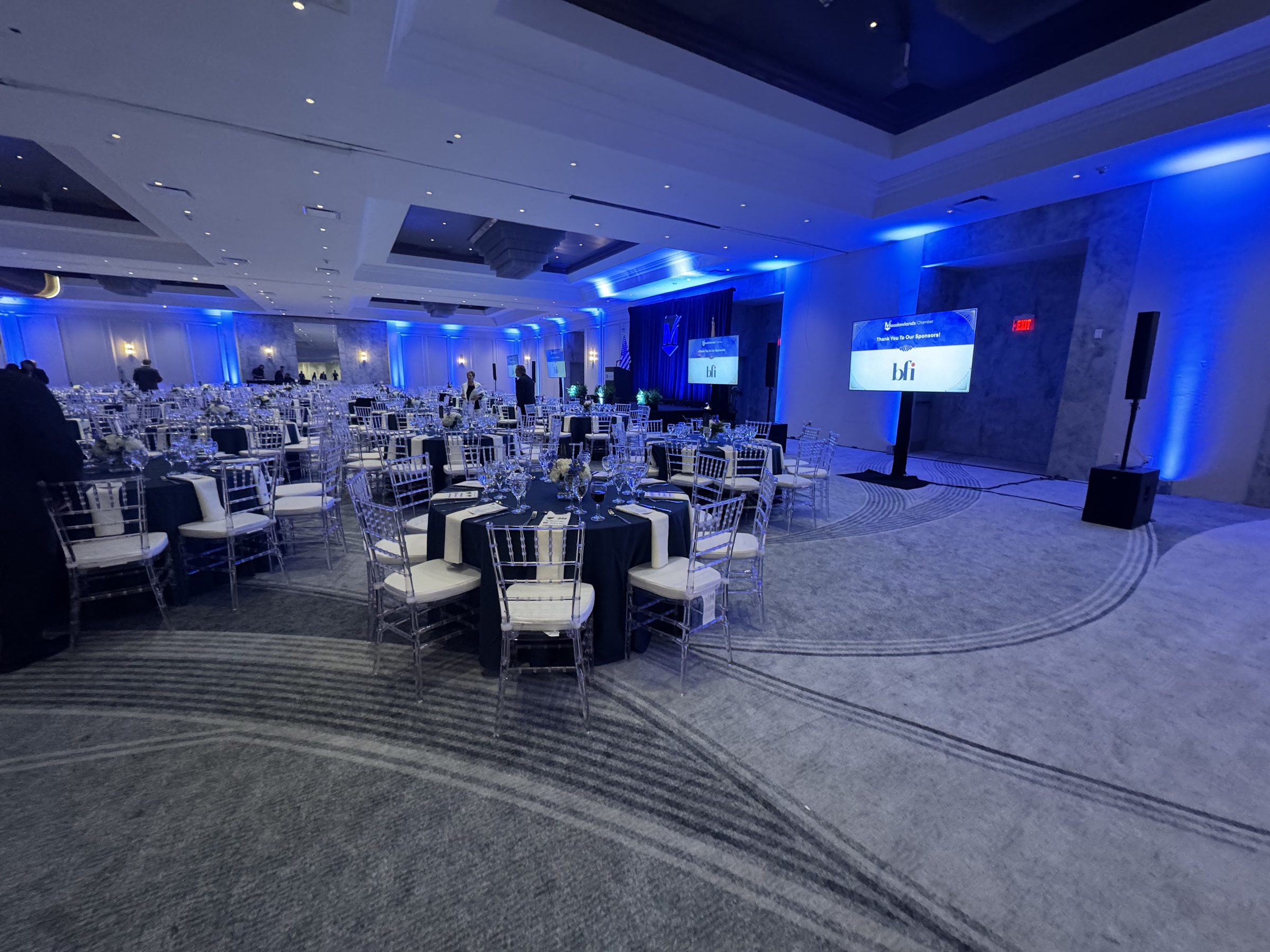 The Horizon Ballroom set for a Meadowlands Chamber dinner, the stage under blue light