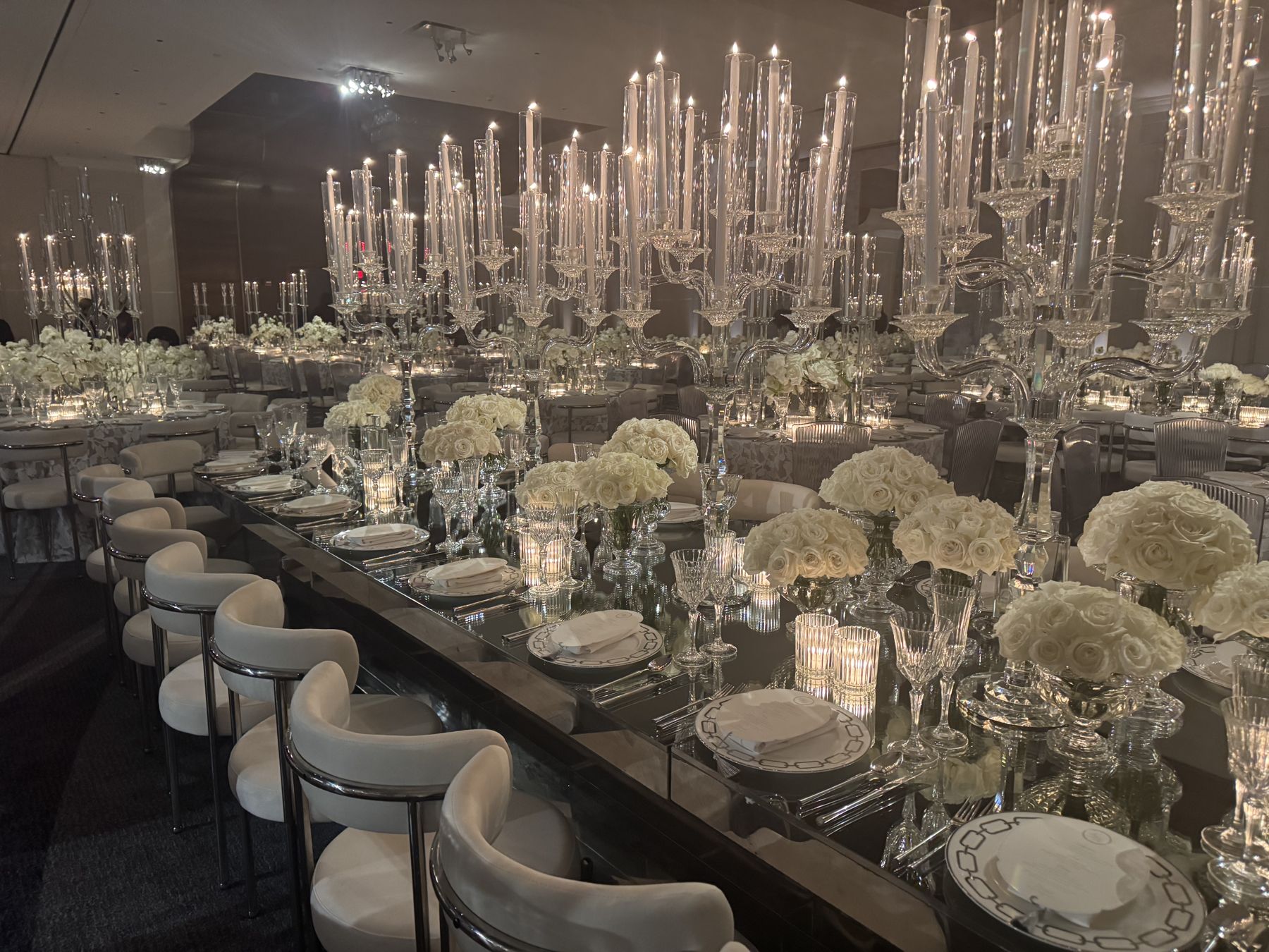 Long tables under crystal candelabra and white roses in the Horizon Ballroom