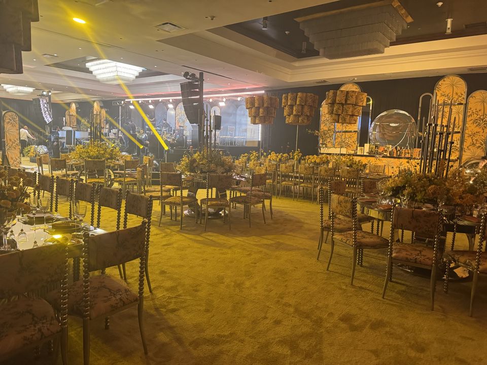 The ballroom set in yellow: palm-print arches, lampshade chandeliers and mirrored tables