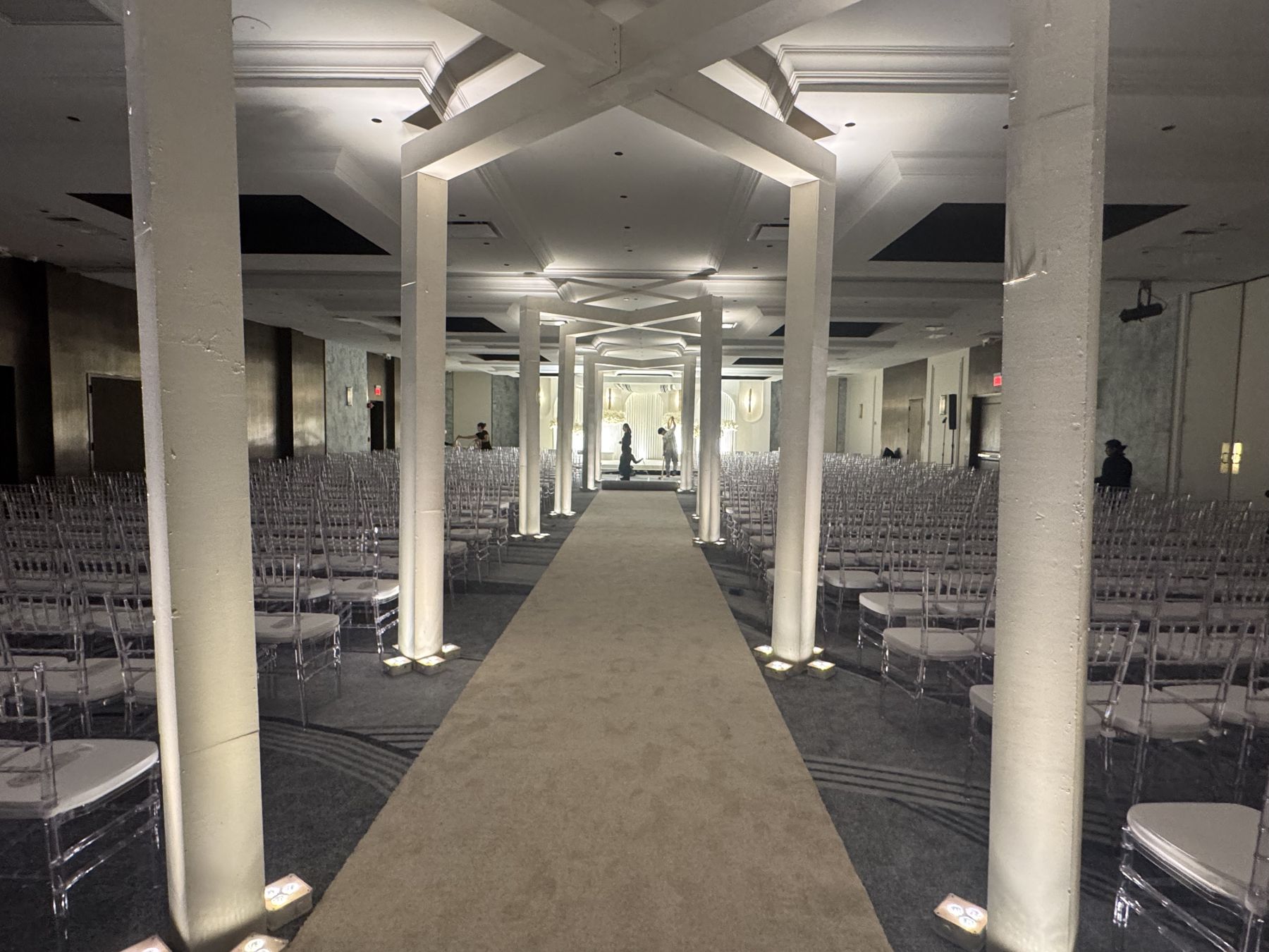 A ceremony aisle under wooden cross beams in the Skyline Ballroom