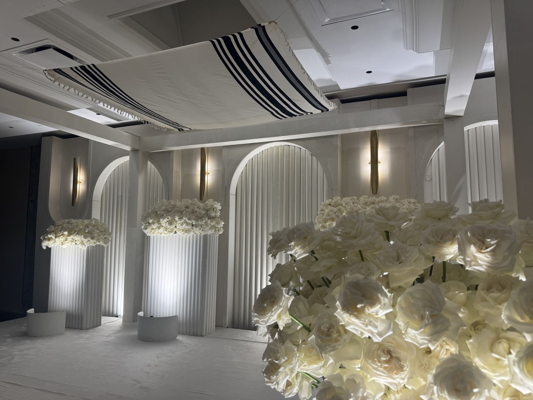 The ceremony stage with white arches and rose columns in the Skyline Ballroom