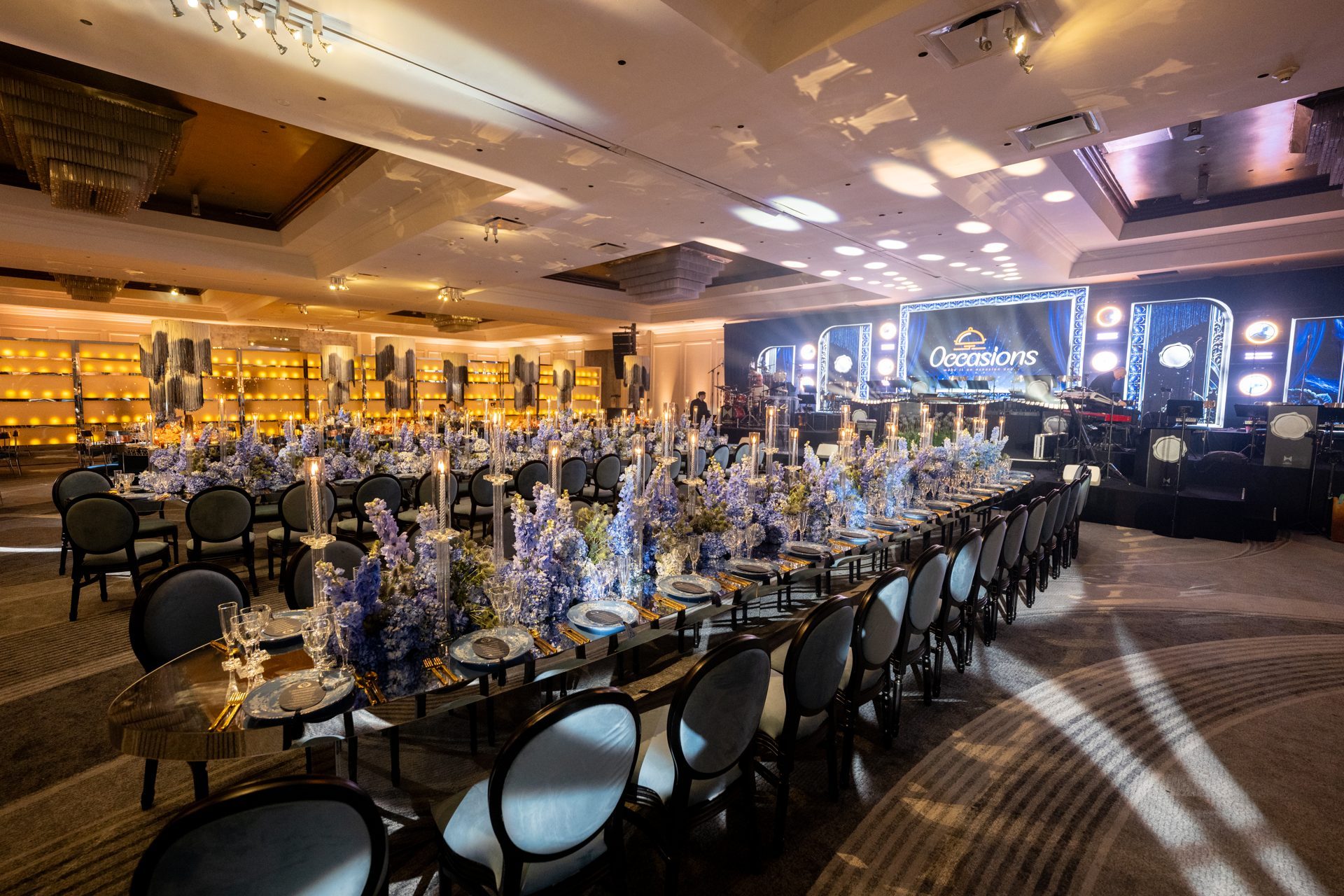 A long royal table dressed in blue florals in the Horizon Ballroom