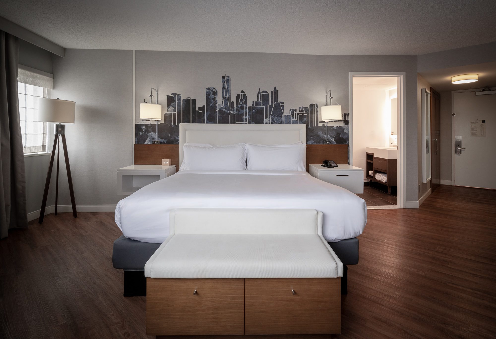 The Blue Panoramic king with an upholstered bench and skyline mural