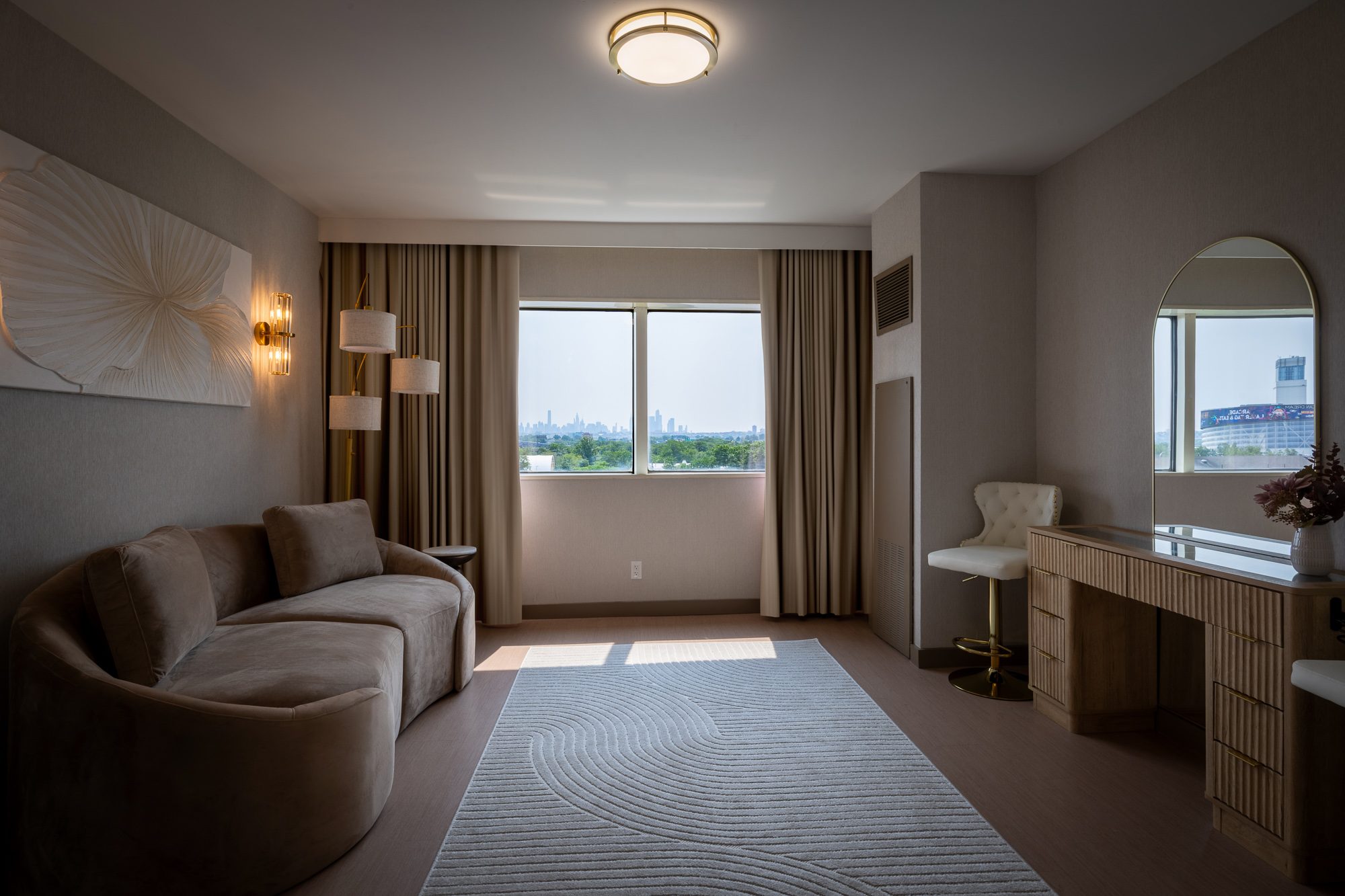 The king suite sitting room with a curved sofa and vanity