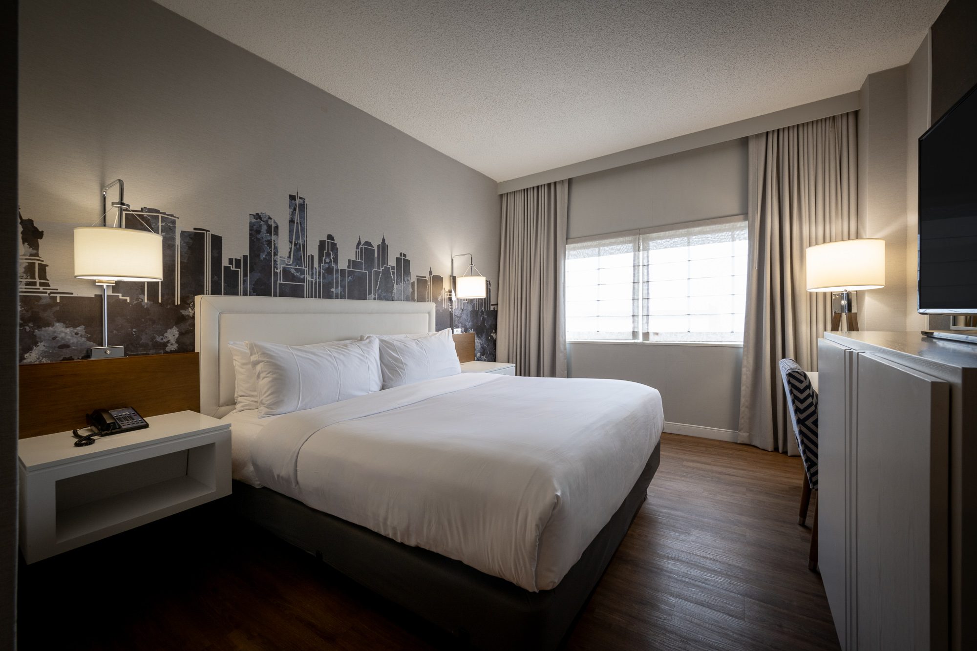 A Blue View king room with the skyline mural and a shaded window